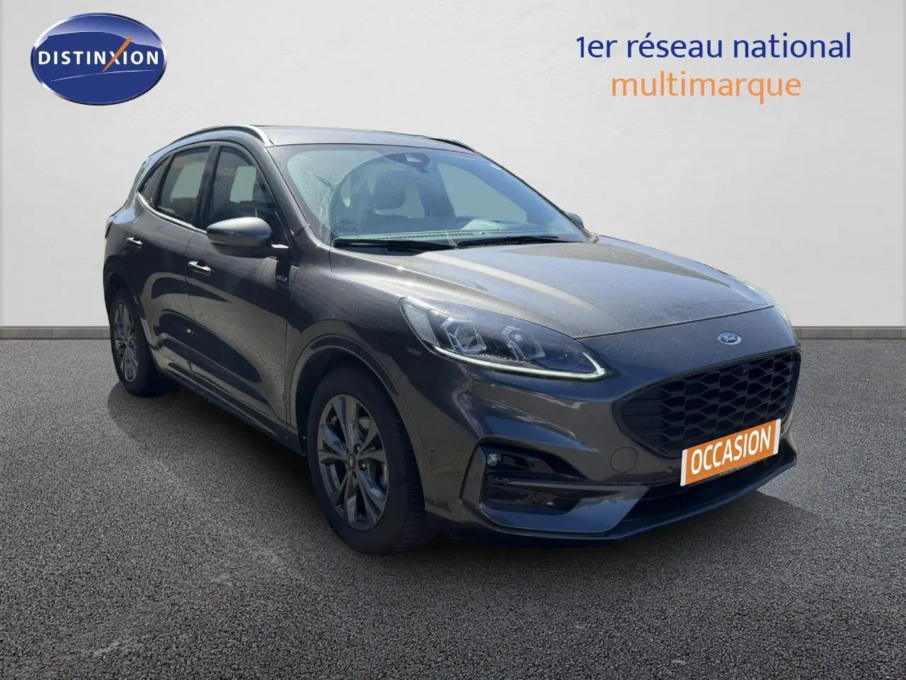 Ford Kuga 2024 gris magnétique métal en 3/4 avant droit, avec calandre noire et jantes alliage.