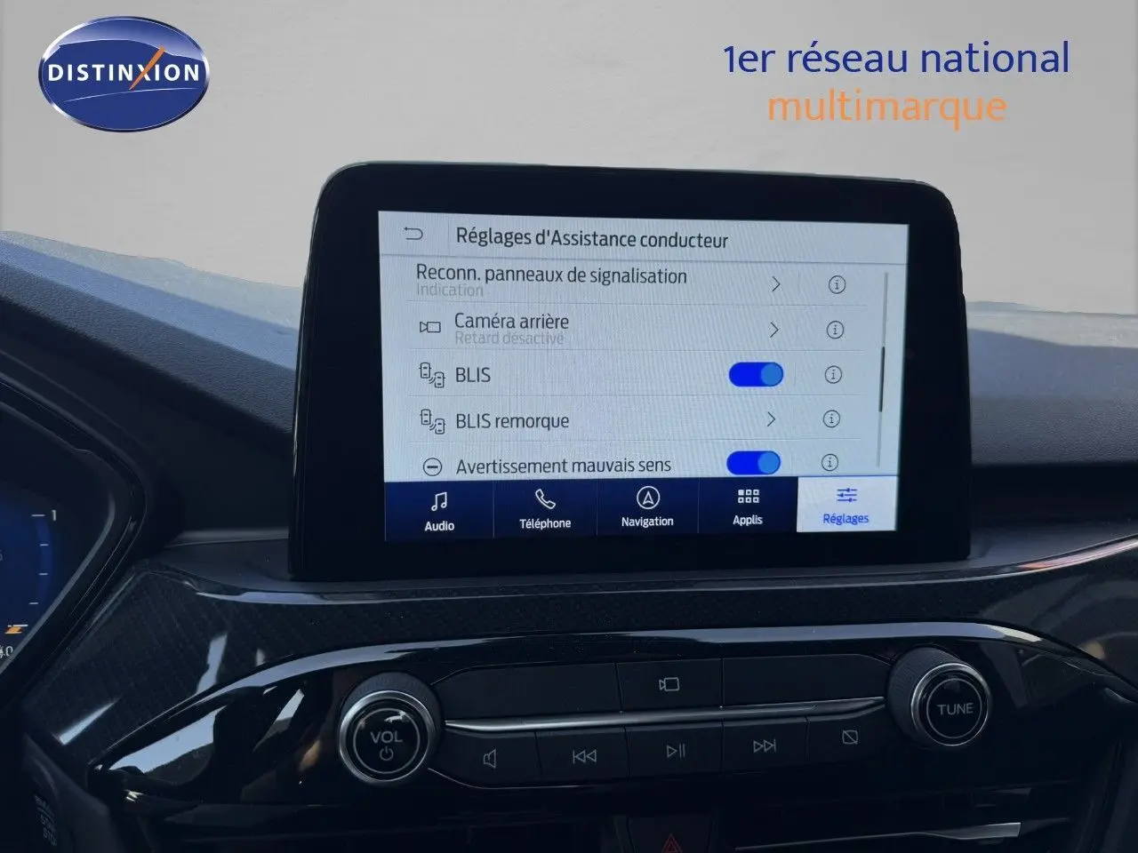 Vue intérieure centrée sur l'écran tactile du tableau de bord du Ford Kuga gris magnétique 2024, affichant les réglages d'assistance.