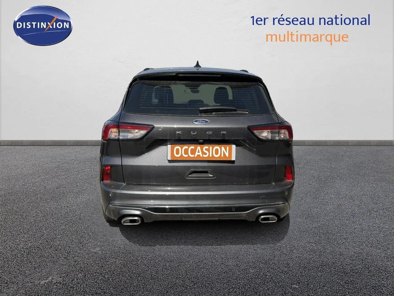 Vue arrière d'un Ford Kuga 2.0D EcoBlue gris magnétique métal avec double sortie d'échappement et badge ST-Line visible.