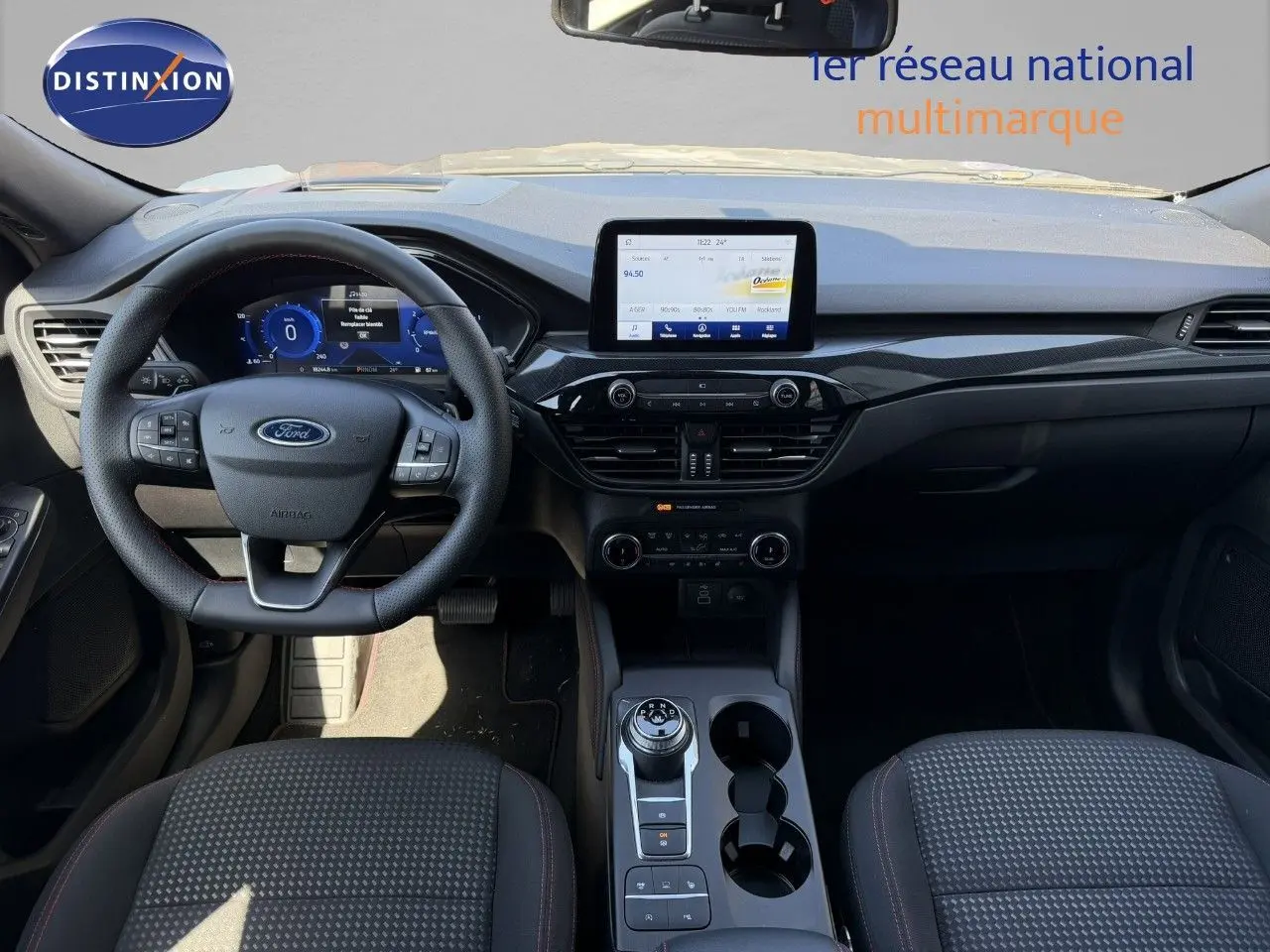 Vue intérieure frontale du Ford Kuga 2024 gris magnétique, avec tableau de bord numérique et écran tactile central.