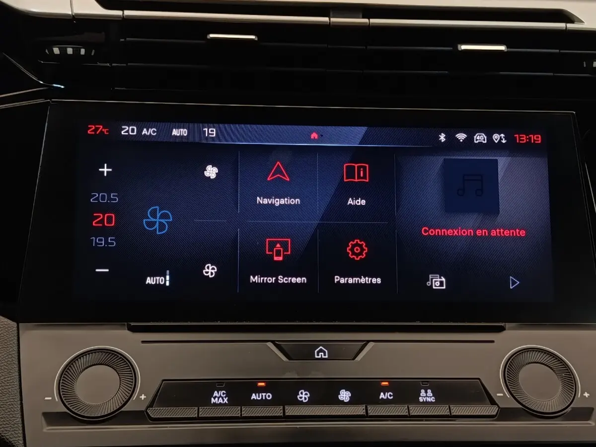Écran tactile central de la Peugeot 308 blanche 2023, affichant la climatisation et les options de navigation.