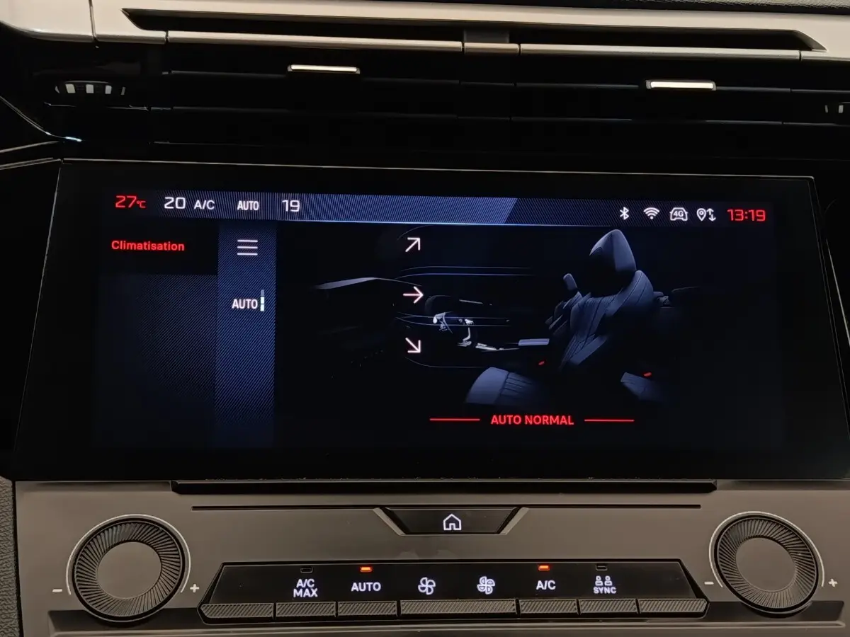 Écran tactile central de la Peugeot 308 blanc, affichant les réglages de climatisation en mode automatique.