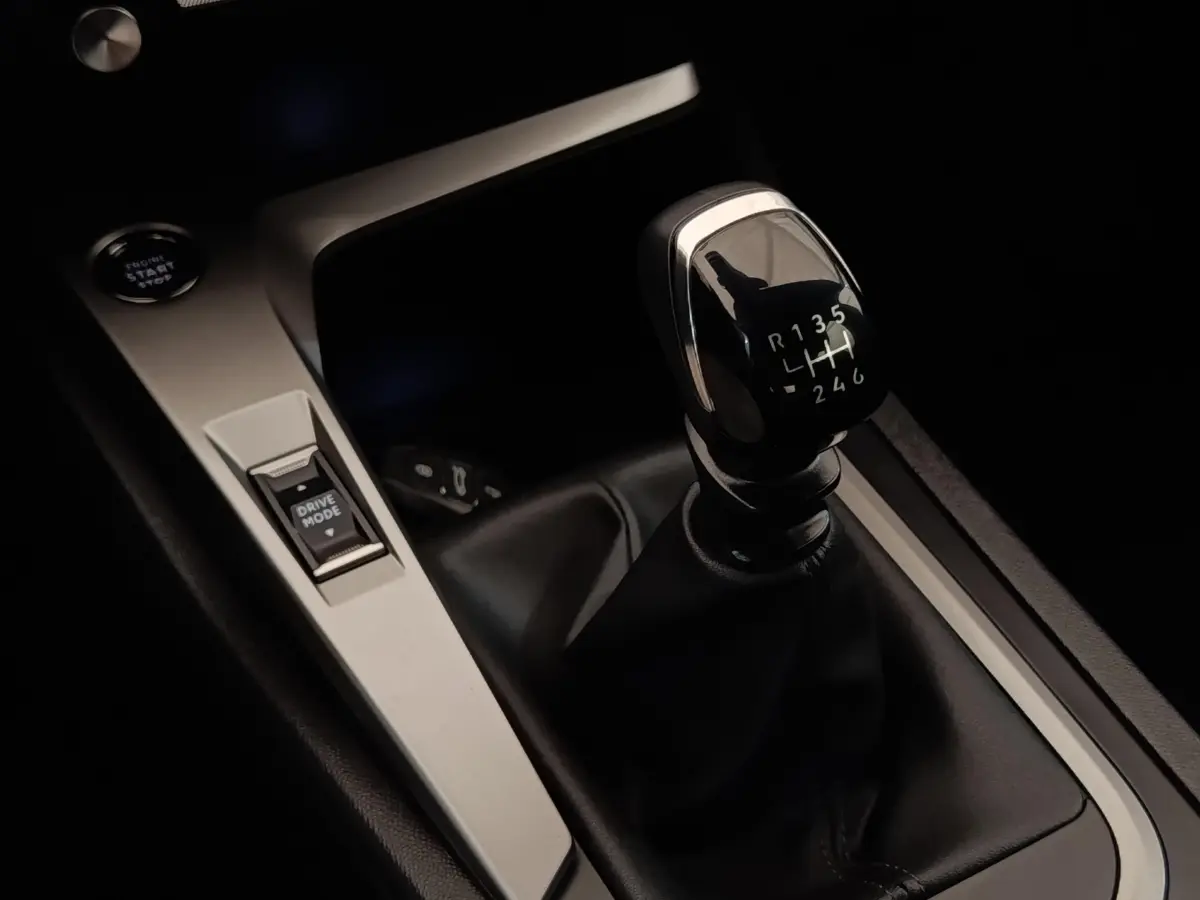 Gros plan sur le levier de vitesses manuel noir et la console centrale argentée de la Peugeot 308 PureTech 130 S&S ACTIVE PACK.