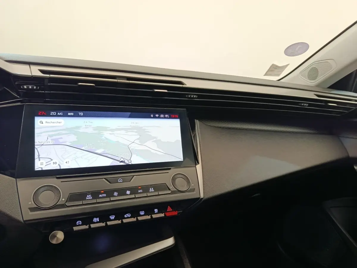 Vue intérieure du tableau de bord de la Peugeot 308 2023 avec écran tactile central affichant la navigation.