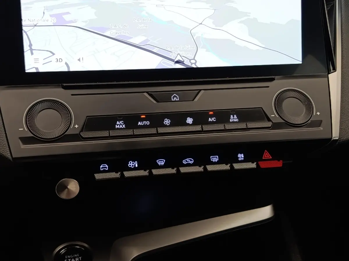 Vue rapprochée du tableau de bord central de la Peugeot 308 2023, avec écran tactile et commandes climatisation éclairées.