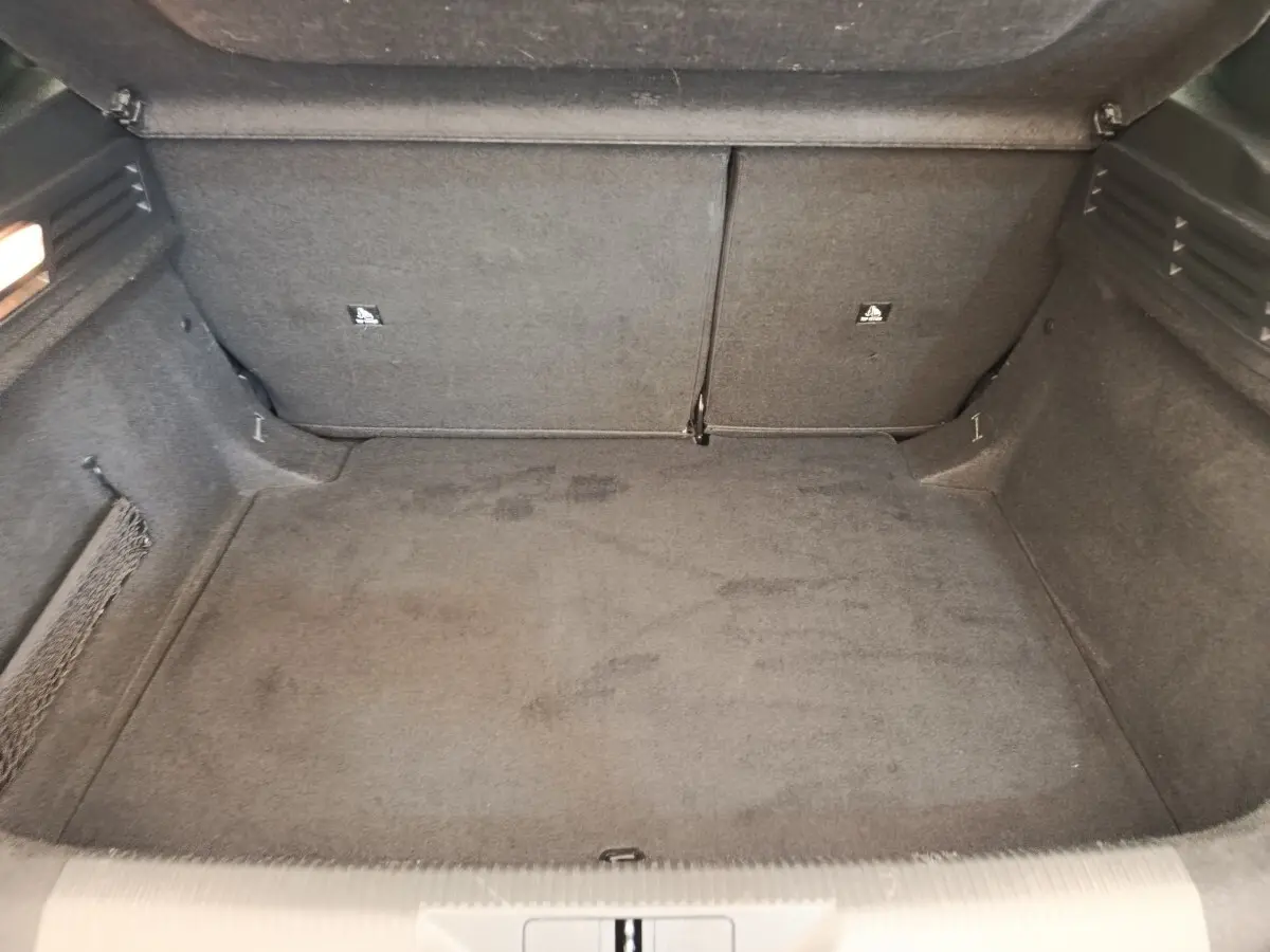 Coffre ouvert de la Peugeot 308 blanche, vue intérieure montrant l'espace de chargement avec banquette arrière rabattable.