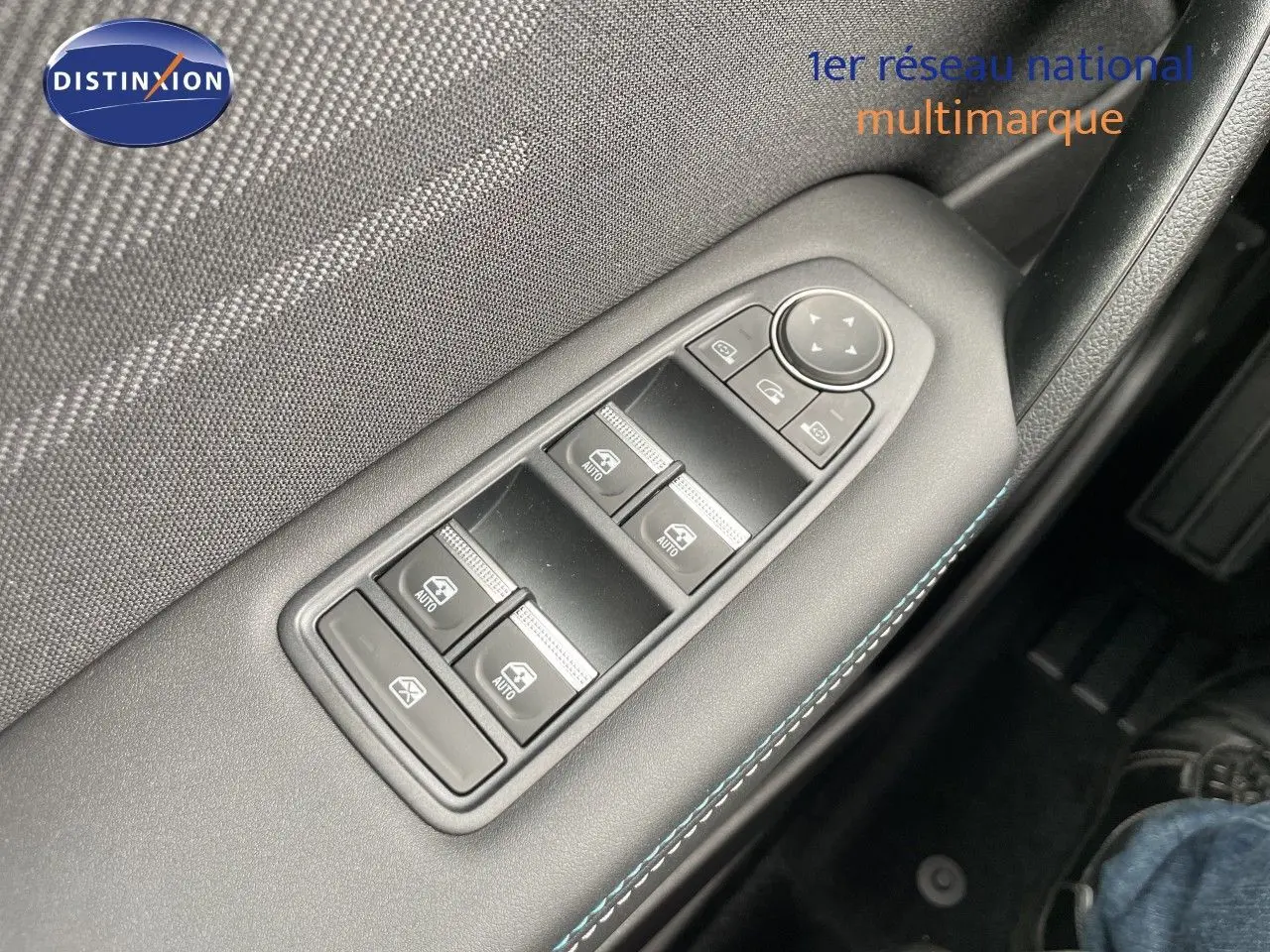 Gros plan sur les commandes des vitres électriques côté conducteur d'une Renault Symbioz gris cassiopée métal.