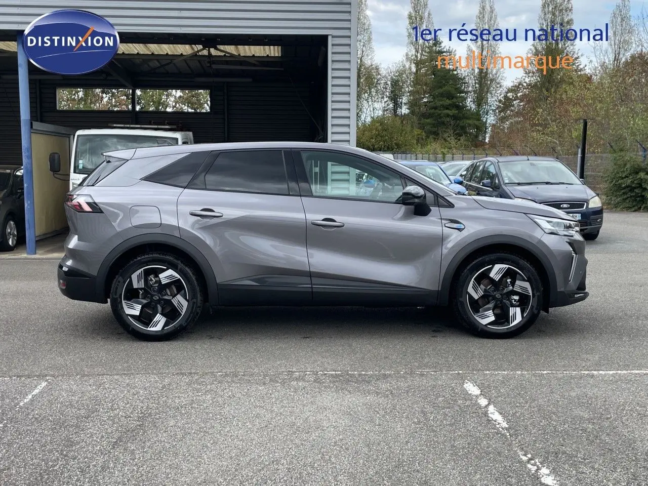 Profil droit du Renault Symbioz gris cassiopée métal, SUV hybride 2026 avec jantes noires et argentées au design moderne.