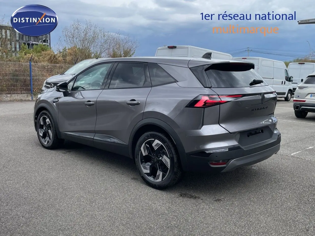Vue 3/4 arrière droite d'un Renault SYMBIOZ gris cassiopée métal avec feux arrière LED et jantes bicolores.