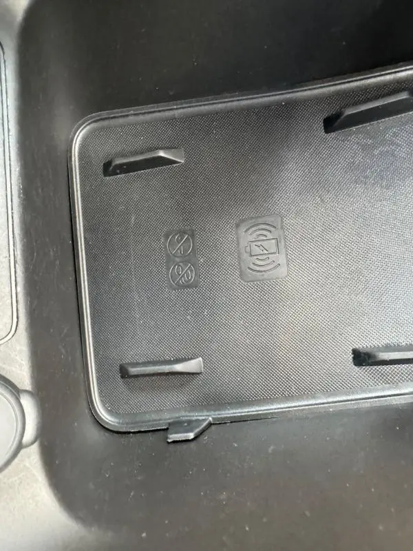 Gros plan sur le support de recharge sans fil noir dans l'habitacle du Jeep Avenger gris foncé 2025.