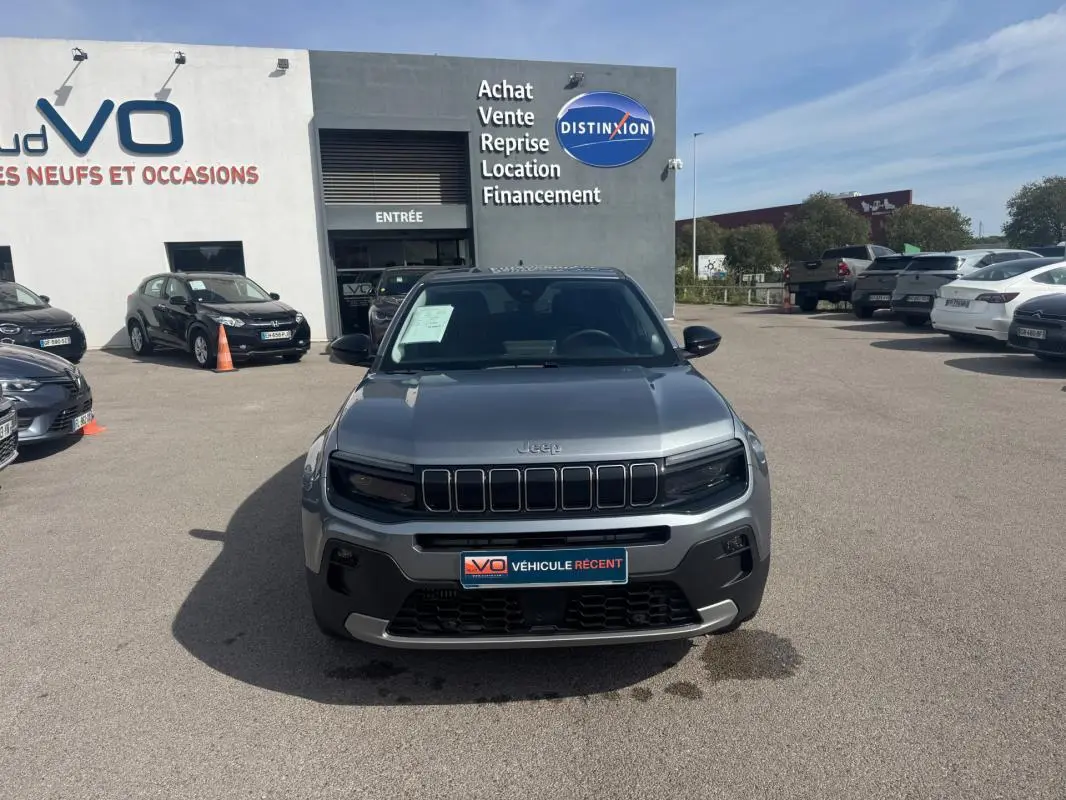 Vue frontale du Jeep Avenger gris foncé 2025, avec sa calandre distinctive à sept fentes et ses phares noirs intégrés.