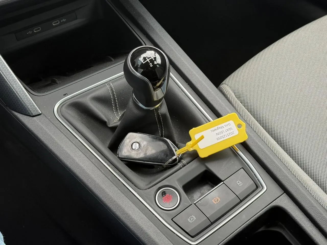 Gros plan sur la console centrale du SEAT LEON 1.5 TSI 115 Style 2025 avec levier de vitesse manuel et clé à proximité.