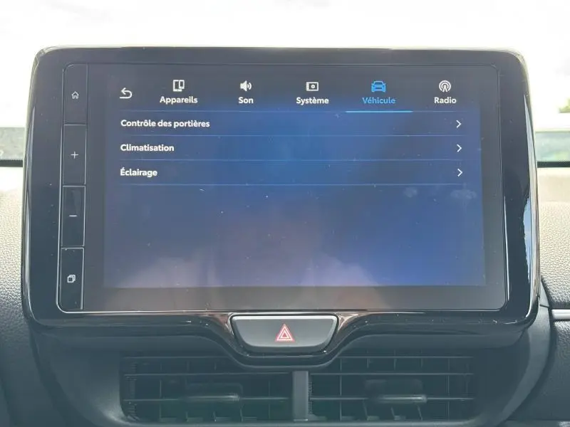 Écran tactile central de la Toyota Yaris 116h Dynamic 2025 affichant le menu véhicule, intérieur noir.