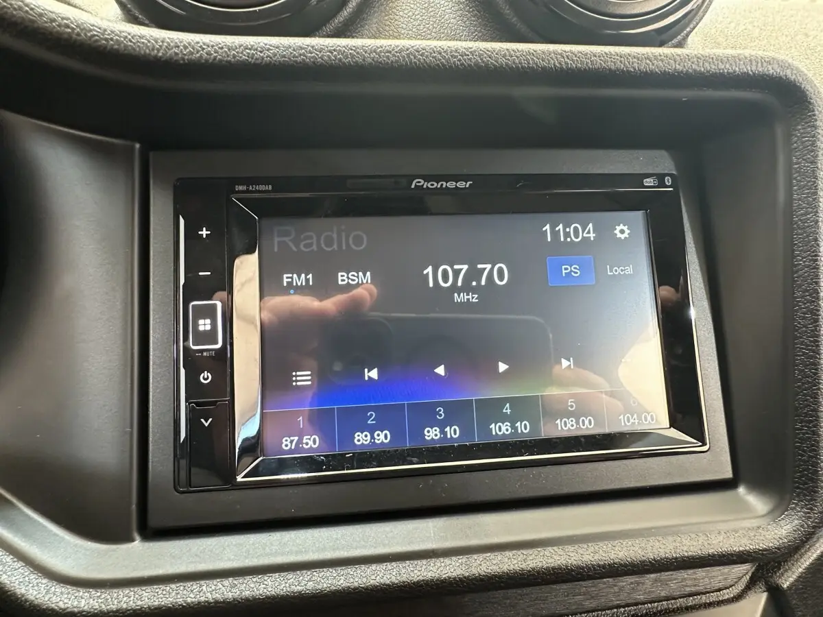 Écran tactile Pioneer du système audio dans l’habitacle de l’AIXAM AMBITION 0.5 CITY PACK blanc, vue rapprochée.