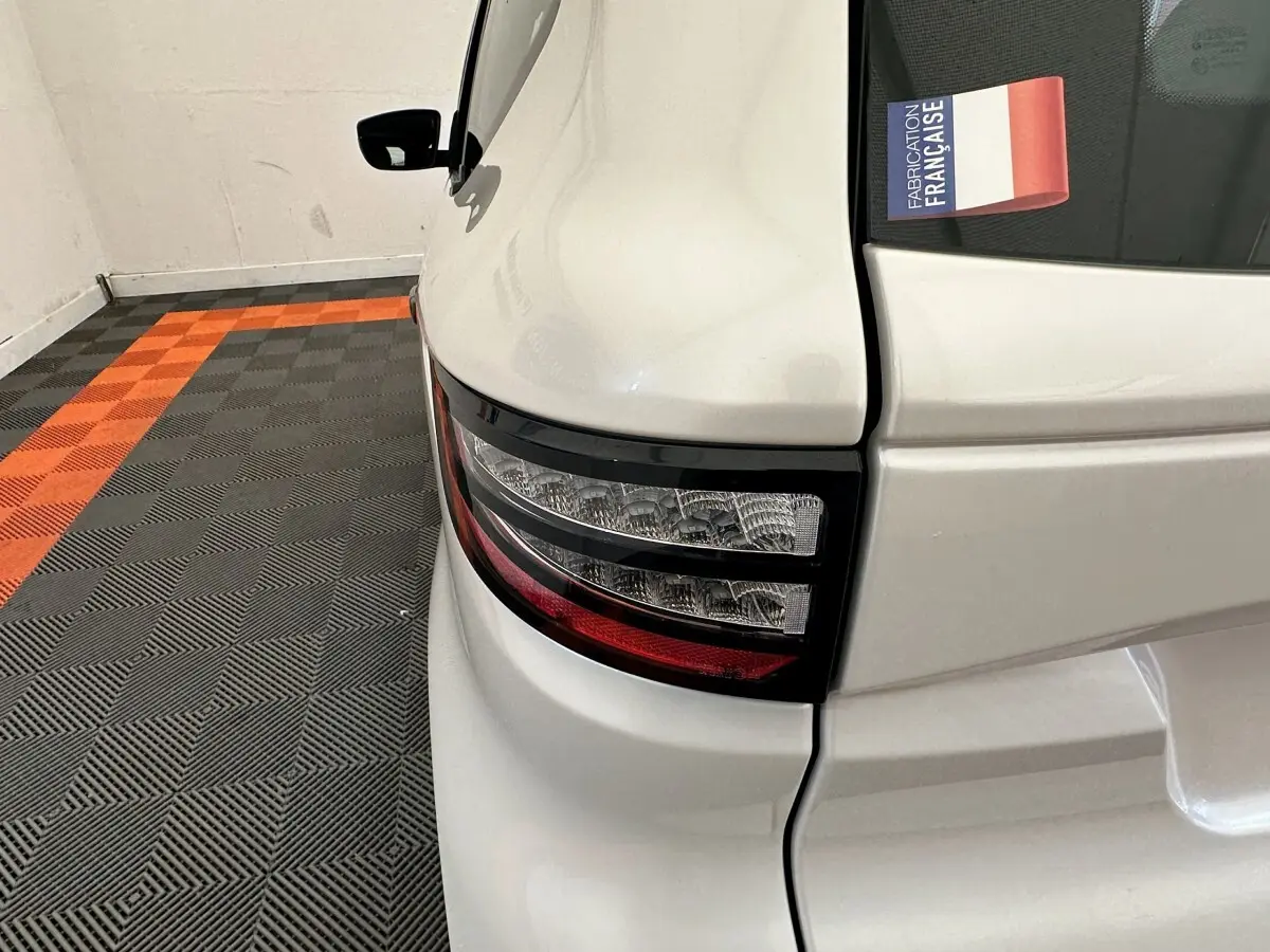 Gros plan sur le feu arrière droit blanc de l'AIXAM AMBITION 0.5 CITY PACK 2026 avec rétroviseur caméra côté conducteur.