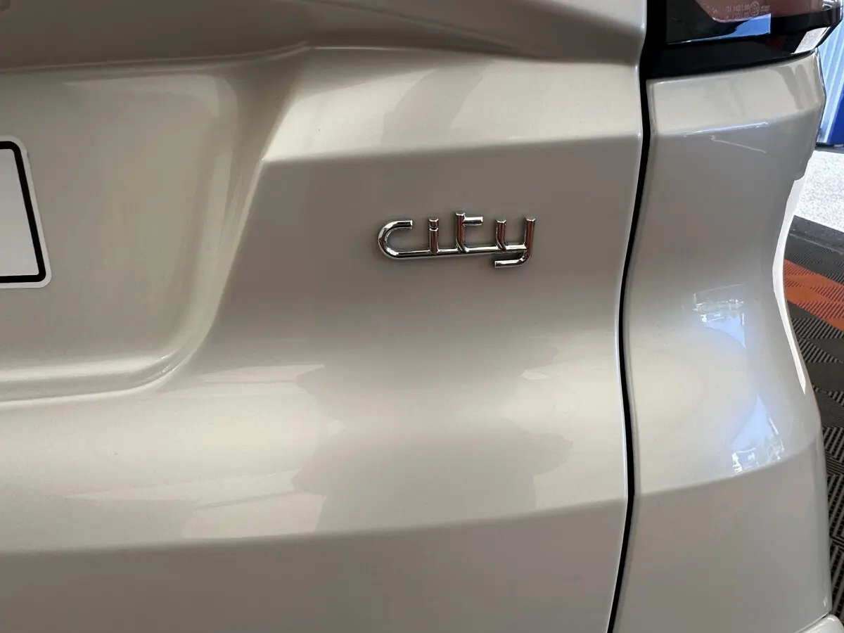 Gros plan sur l'arrière blanc de l'AIXAM AMBITION 0.5 CITY PACK avec l’inscription chrome "city".