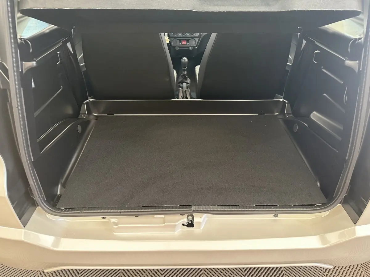 Vue arrière ouverte du coffre spacieux de l'AIXAM AMBITION 0.5 CITY PACK blanc, intérieur noir minimaliste.