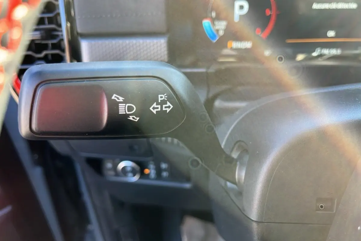 Gros plan sur le commodo gauche du Ford Ranger Raptor gris commandeur, avec commandes des feux et clignotants visibles.