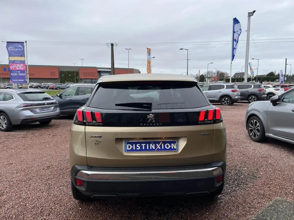 Vue arrière d'un Peugeot 3008 jaune clair métallisé, avec feux arrière à trois griffes rouges distinctives.
