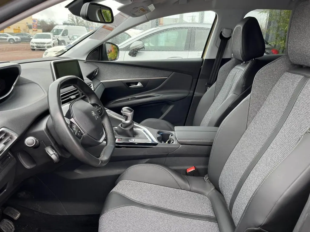 Vue intérieure côté conducteur du Peugeot 3008 2017, montrant la sellerie TEP et tissu grise et la boîte manuelle.