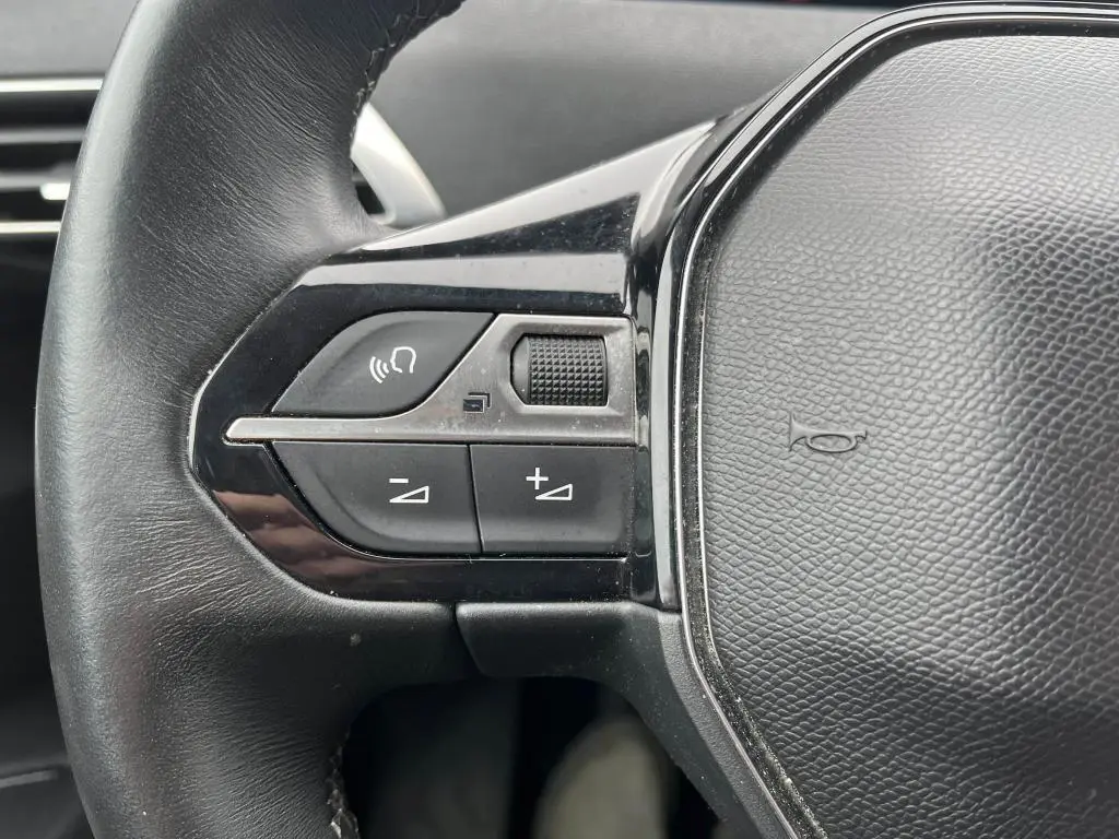 Gros plan sur les commandes gauche du volant noir du Peugeot 3008 2017, avec boutons de volume et téléphone.