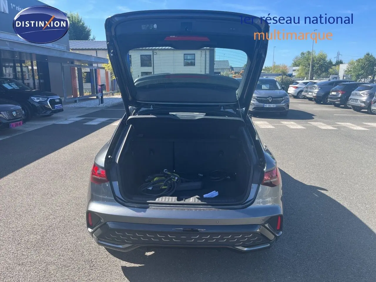 Vue arrière d'une Audi A3 Sportback gris Daytona avec coffre ouvert montrant le chargeur hybride rechargeable.