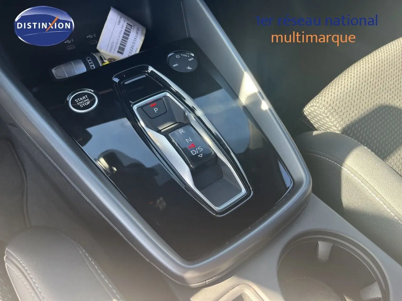 Gros plan sur la console centrale de l'Audi A3 Sportback 40 TFSIe 2025 avec levier de vitesse automatique et bouton start/stop.