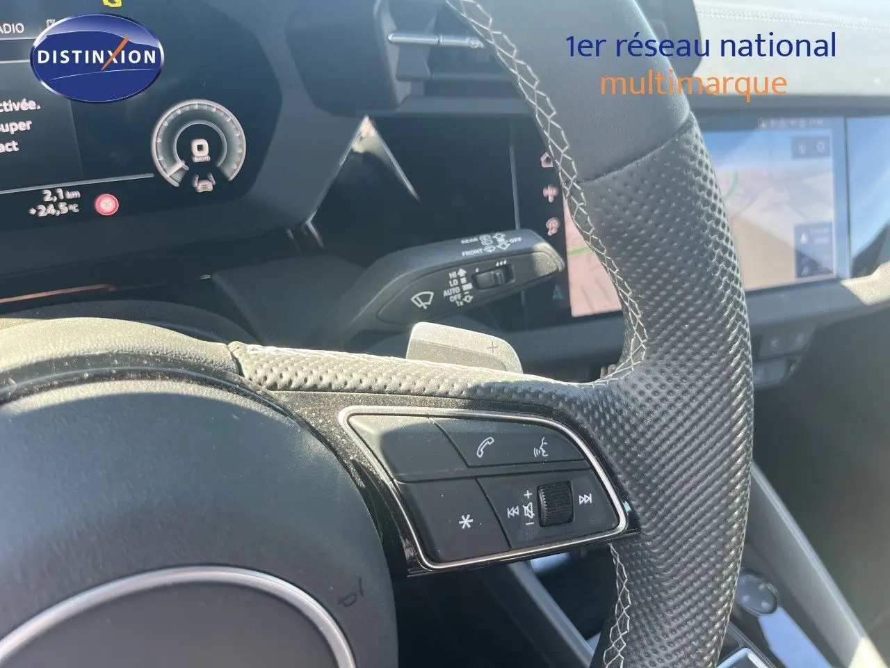 Gros plan sur le volant en cuir perforé avec commandes intégrées et tableau de bord numérique de l'Audi A3 Sportback 2025.