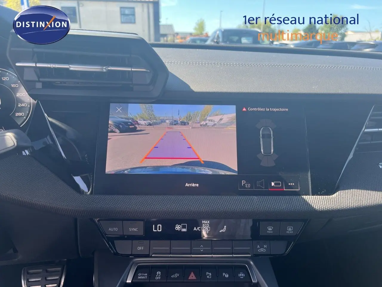 Vue intérieure du tableau de bord de l'Audi A3 Sportback 2025 avec écran de caméra de recul et commandes climatisation.
