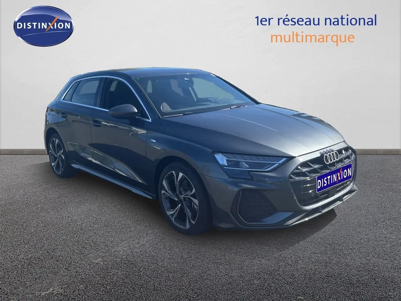 Audi A3 Sportback gris Daytona en 3/4 avant droit, avec jantes alliage et calandre S-Line distinctive.