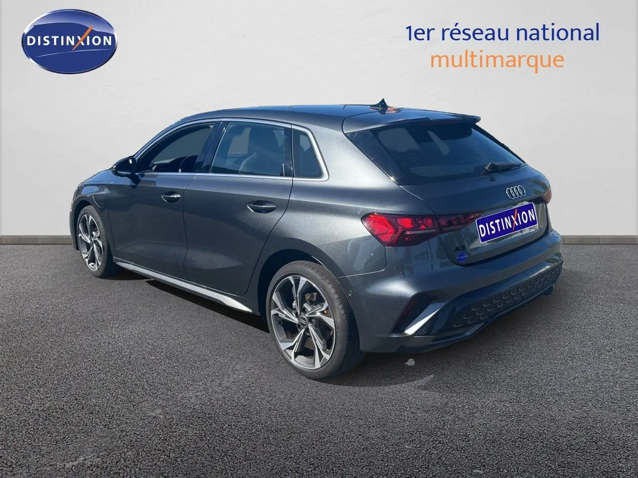 Audi A3 Sportback gris Daytona vue 3/4 arrière droit, finition S-Line avec jantes alliage et feux LED distinctifs.