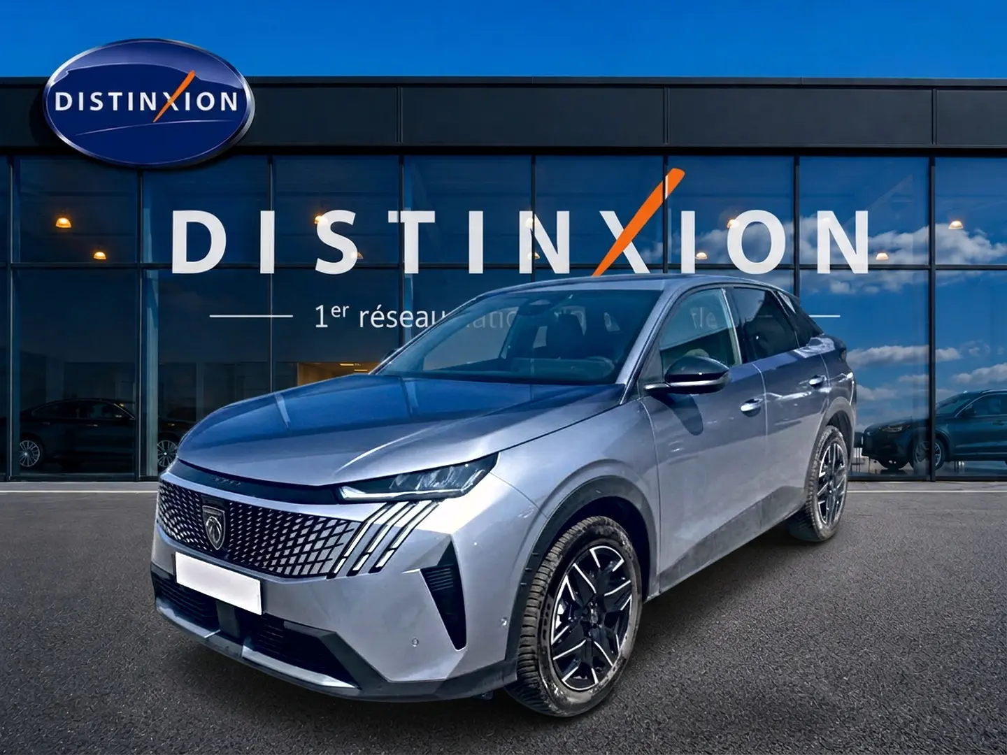 Peugeot 3008 gris en 3/4 avant droit, avec calandre distinctive et jantes alliage noires devant showroom Distinxion.
