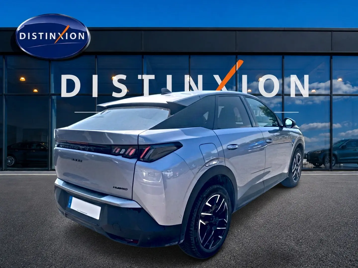 Peugeot 3008 gris vue 3/4 arrière droit, avec jantes alu noires et toit noir contrasté, devant un bâtiment Distinxion.