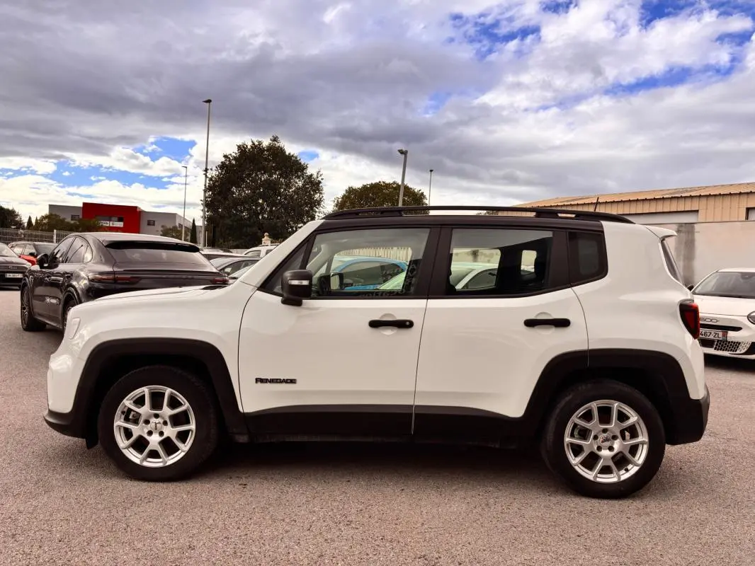 Jeep Renegade blanc vue de profil côté gauche, avec jantes argentées et éléments noirs contrastants sur les passages de roues.