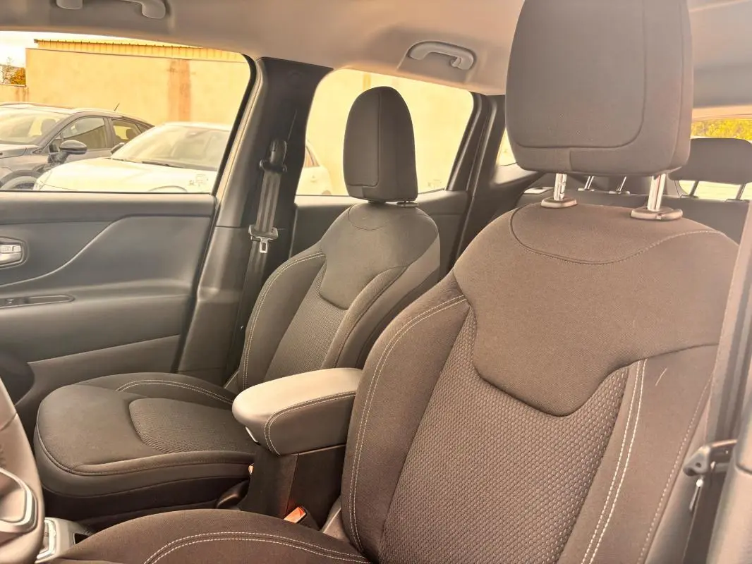 Vue intérieure des sièges avant en tissu noir du Jeep Renegade 2024, côté droit, avec accoudoir central visible.