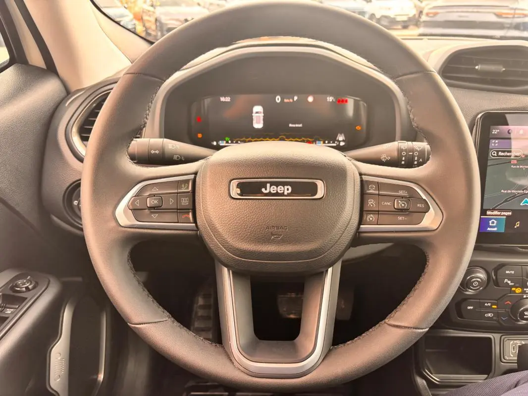 Vue rapprochée du volant noir du Jeep Renegade 2024 avec tableau de bord numérique et commandes intégrées.