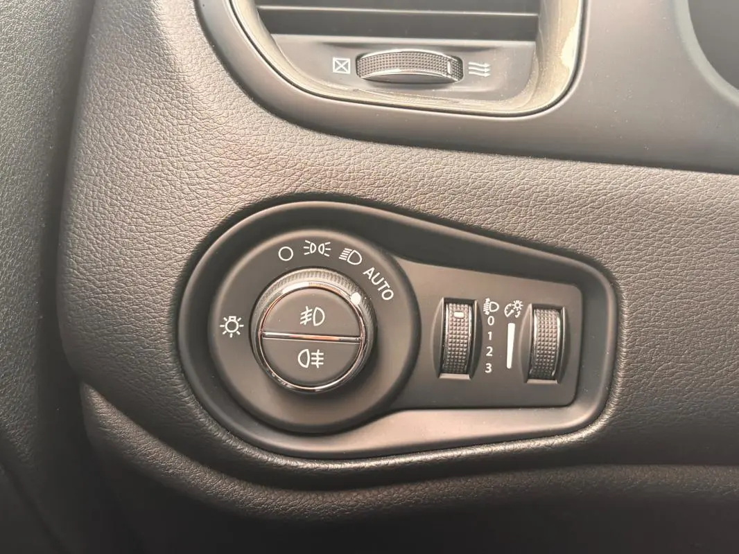 Gros plan sur la molette de commande des phares du tableau de bord du Jeep Renegade 2024, finition Altitude.
