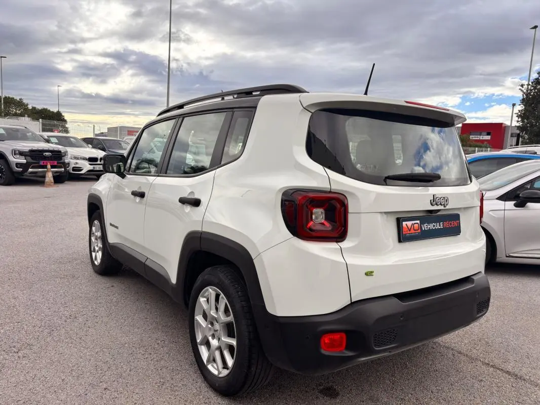 Jeep Renegade blanc vue 3/4 arrière droit, avec feux arrière distinctifs et badge e-Hybrid visible.