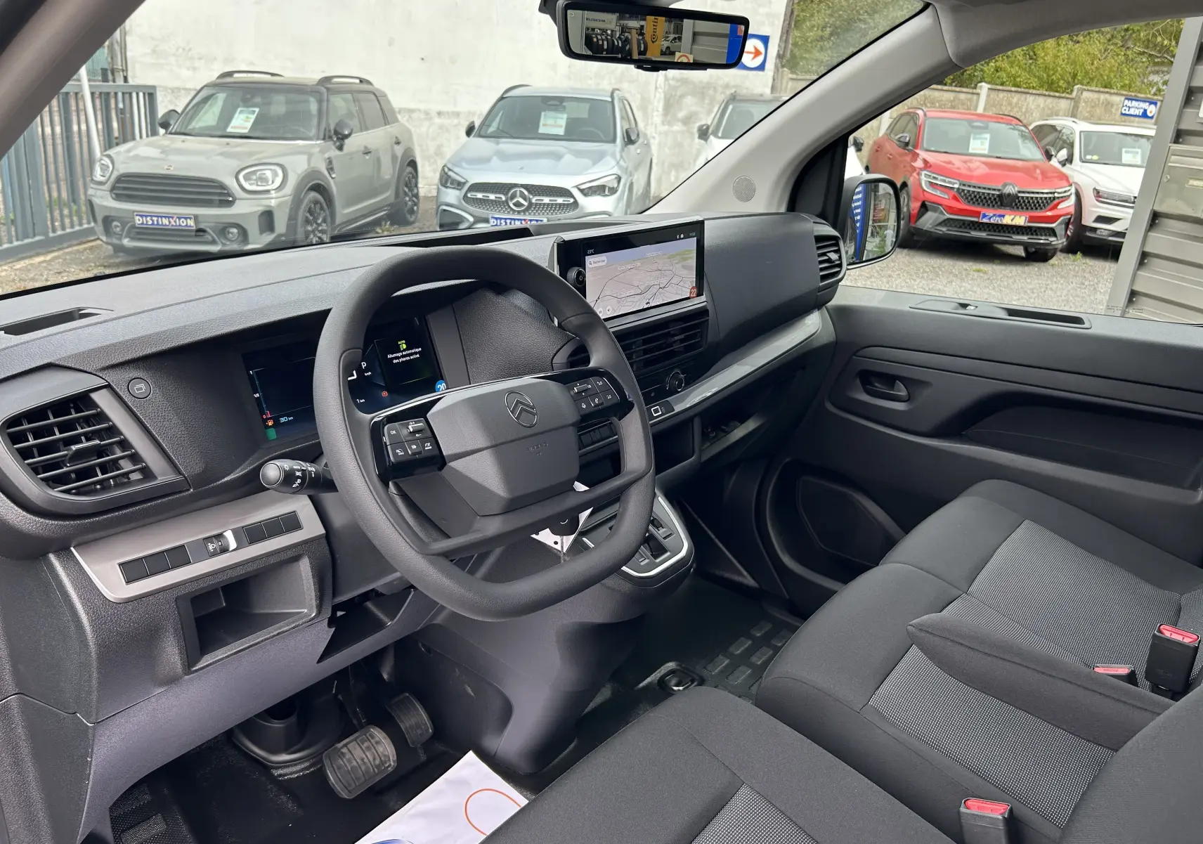 Vue intérieure côté conducteur du Citroën Jumpy Ph.2 gris titane, tableau de bord moderne avec écran tactile et volant multifonction.