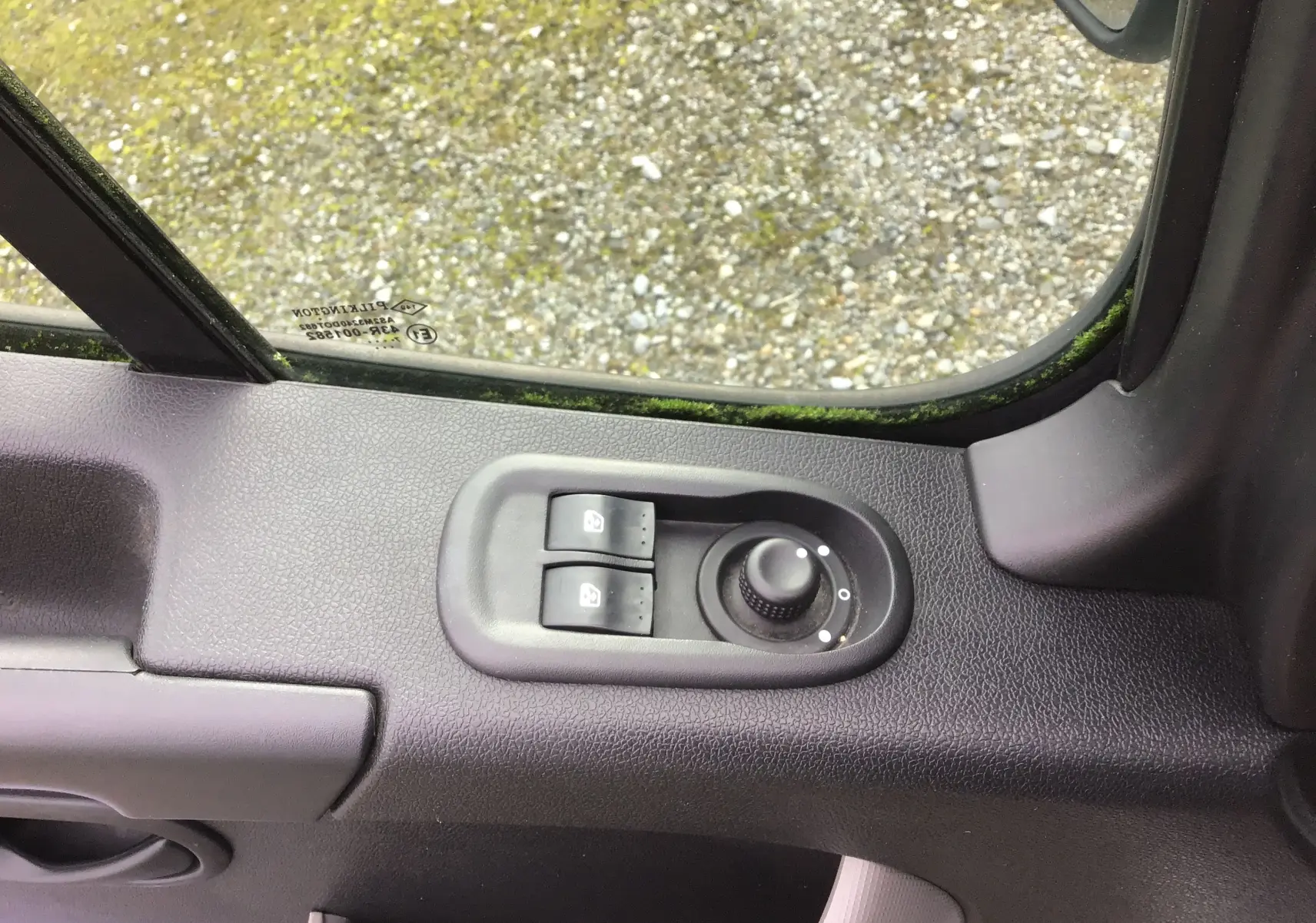 Vue rapprochée du panneau de commande des vitres et rétroviseurs côté gauche d’un Renault Master Combi III blanc de 2017.