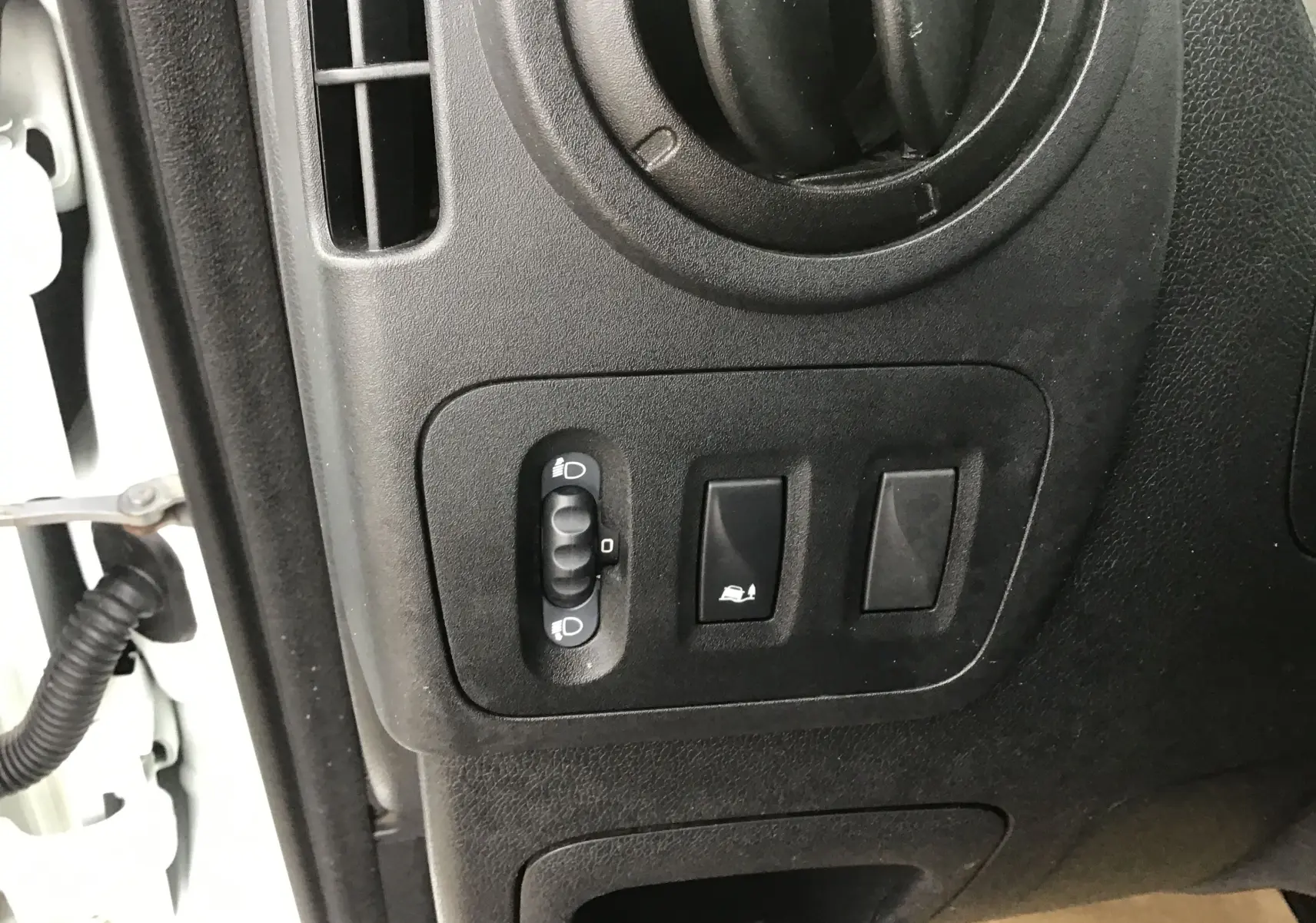 Vue rapprochée du tableau de bord côté gauche du Renault Master Combi III blanc, montrant les commandes d’éclairage et de réglage.