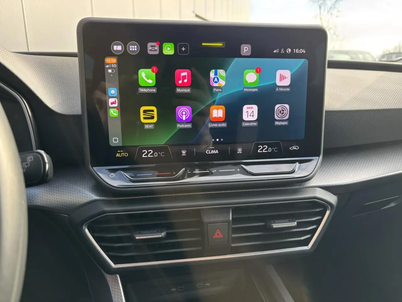 Vue rapprochée de l’écran tactile central du tableau de bord du SEAT Leon 2025, affichant l’interface Apple CarPlay.