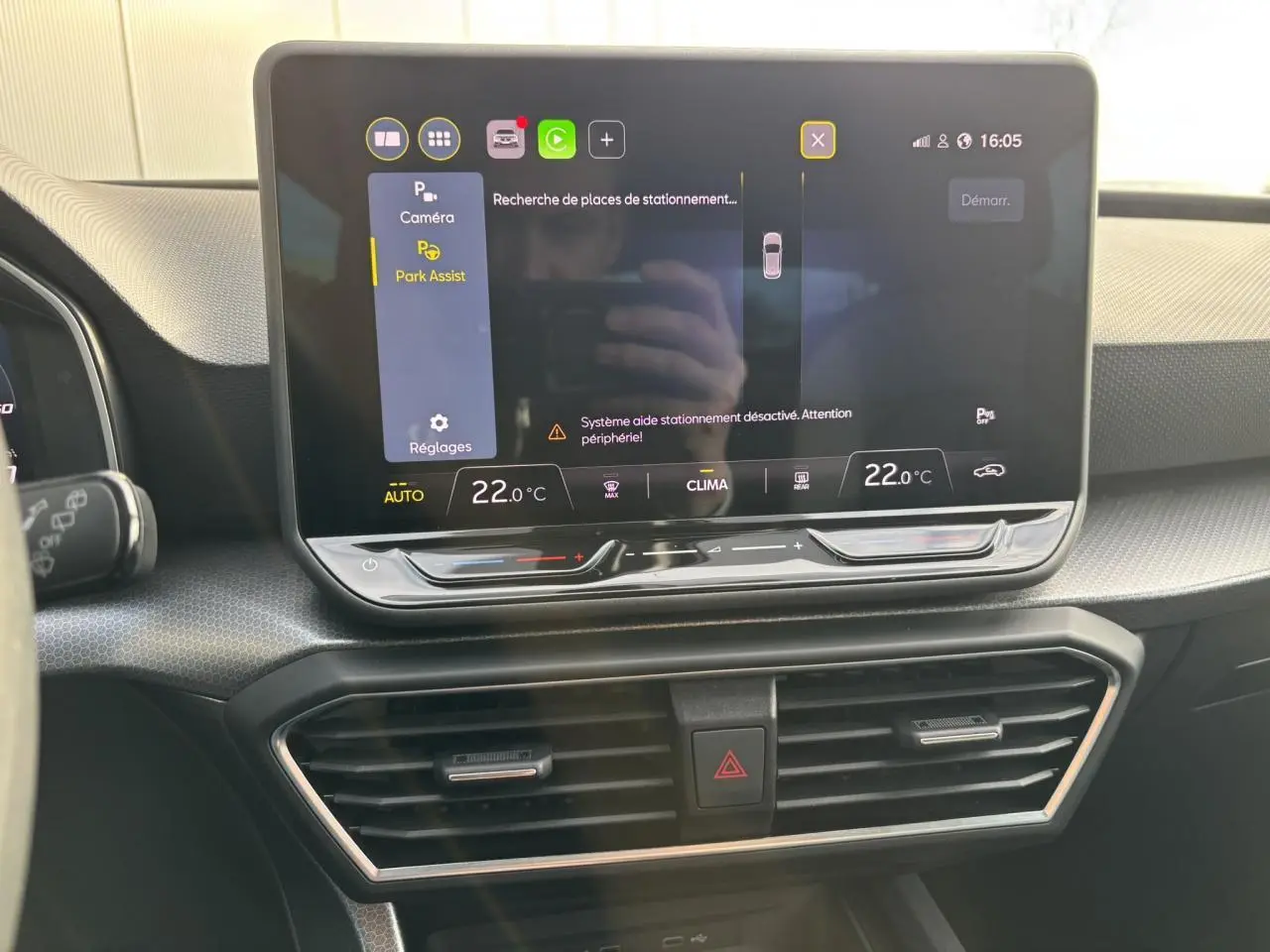 Écran tactile central du tableau de bord du SEAT Leon 2025 affichant l'assistance au stationnement et la climatisation à 22°C.