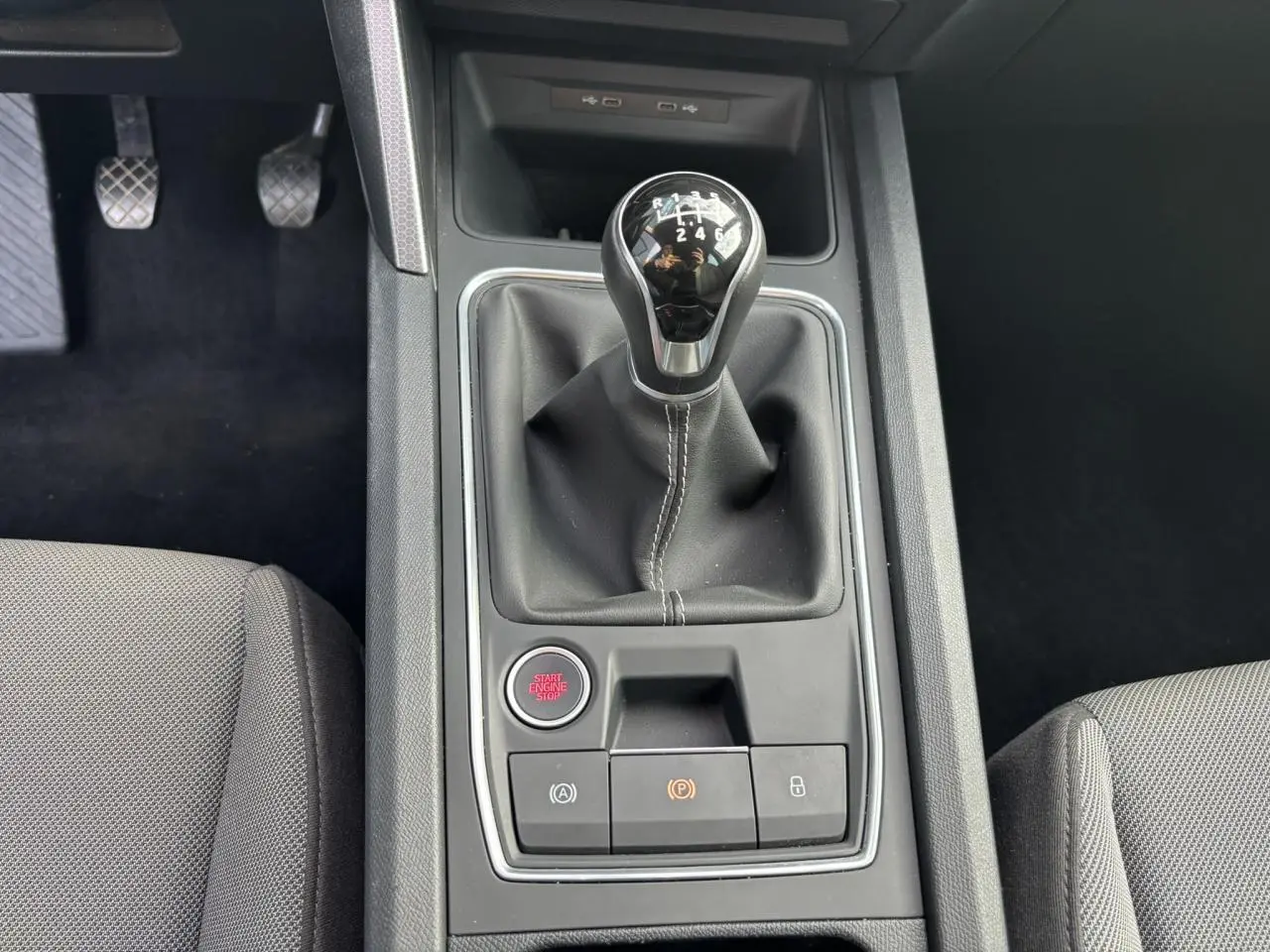 Vue rapprochée de la console centrale du SEAT LEON 2.0 TDI 115 Style 2025, avec levier de vitesse manuel et bouton start/stop.