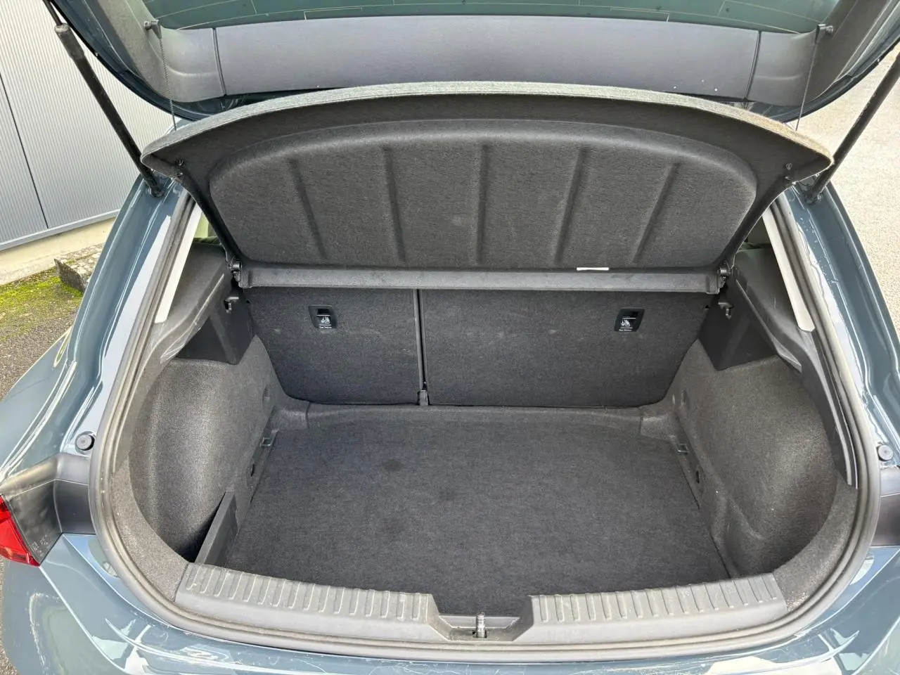 Coffre ouvert vu de l'arrière d'une SEAT Leon 2.0 TDI 115 Style bleu Fjord, montrant l'espace de chargement vide.