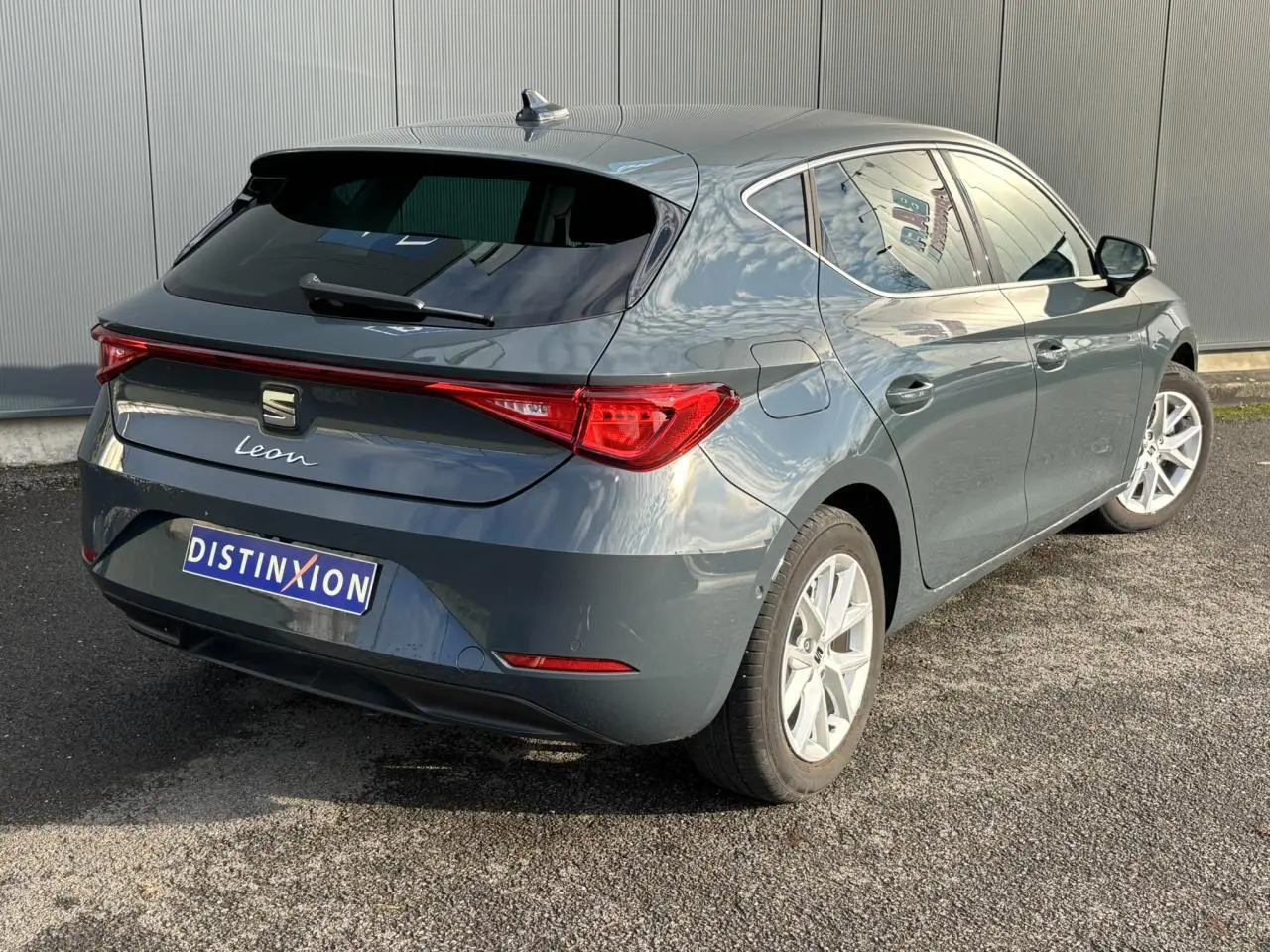 Vue 3/4 arrière droite d'une SEAT Leon 2.0 TDI 115 Style bleu Fjord avec jantes alliage 16 pouces et vitres surteintées.