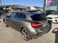 Vue 3/4 arrière droite d'une Mercedes GLA 200 Fascination gris foncé métal, avec jantes alliage et feux arrière LED visibles.