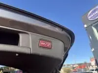 Vue rapprochée de l'ouverture du coffre d'un Mercedes GLA 200 Fascination gris foncé métal, avec bouton d'ouverture visible.