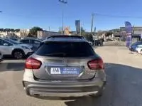 Vue arrière d'un Mercedes GLA 200 Fascination gris foncé métal, stationné en extérieur dans un parking ensoleillé.