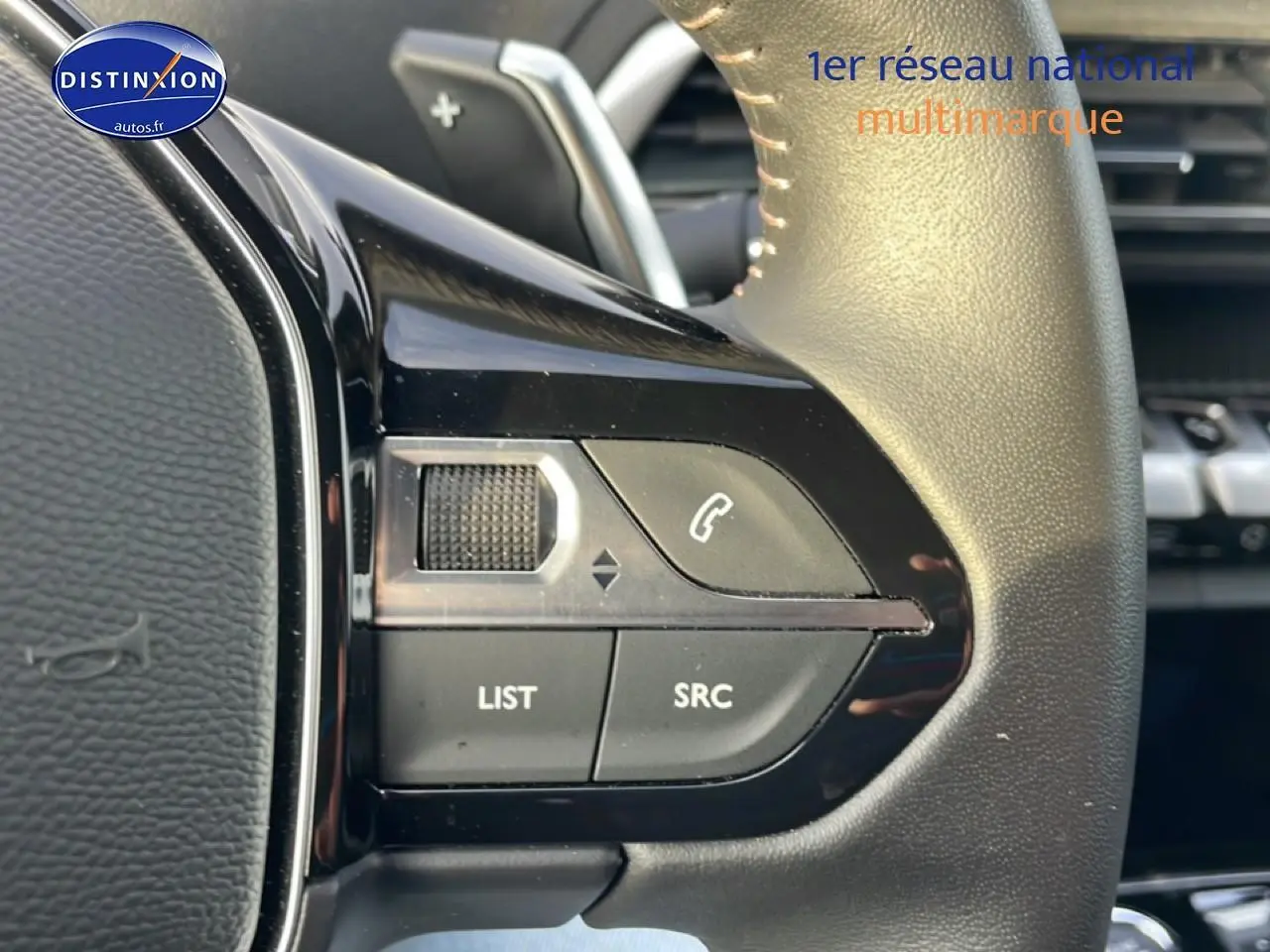 Gros plan sur les commandes audio au volant cuir noir du Peugeot 3008 Plug-in Hybrid 2024, côté gauche.